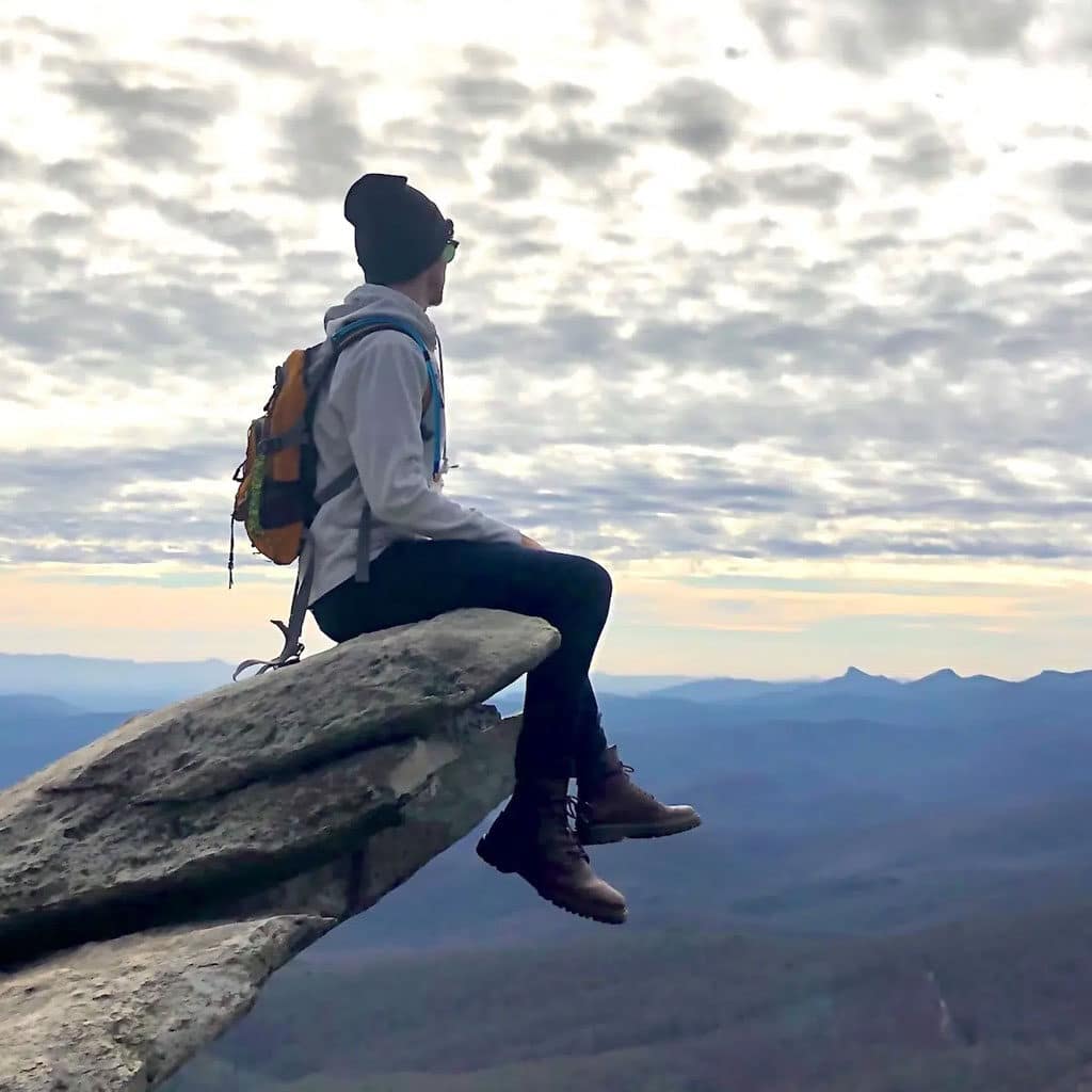 photo of client sitting on top of a mountain